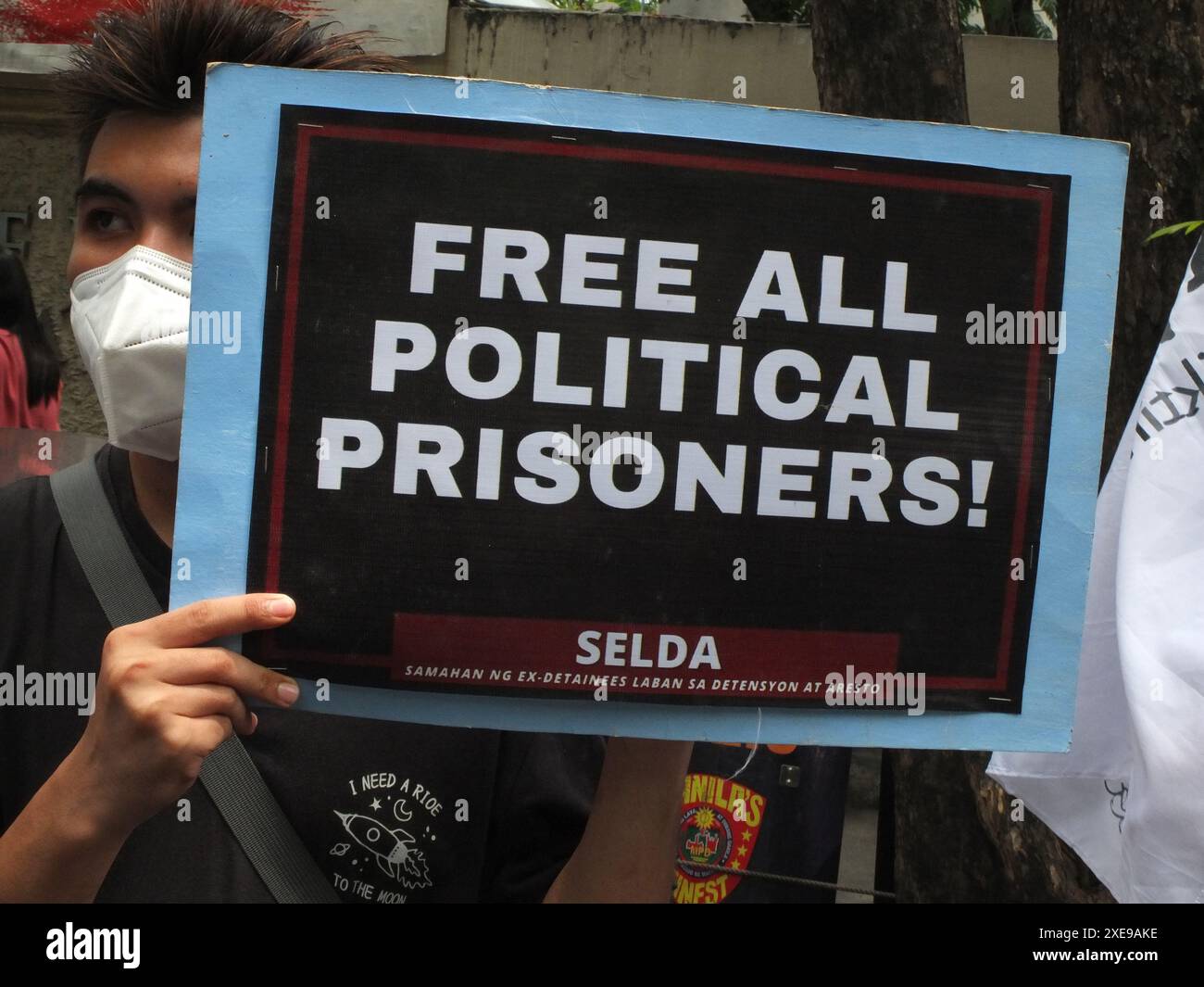 Manila, Philippinen. Juni 2024. Ein Demonstrant hält ein Plakat mit einem Slogan, der alle politischen Gefangenen während der Demonstration freilässt. SELDA (Vereinigung ehemaliger Häftlinge gegen Inhaftierung und Festnahme) ruft erneut dazu auf, die Folter einzustellen, alle Opfer und Überlebenden dieses abscheulichen Verbrechens zu bestrafen und alle politischen Gefangenen unter dem Regime von Präsident Marcos Jr. freizulassen. (Foto von Josefiel Rivera/SOPA Images/SIPA USA) Credit: SIPA USA/Alamy Live News Stockfoto