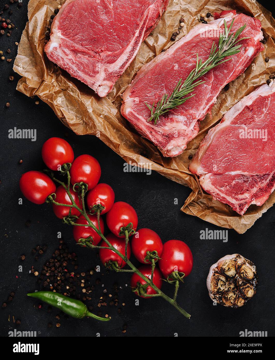 Rohe Streifen-Steaks auf Backpapier Stockfoto