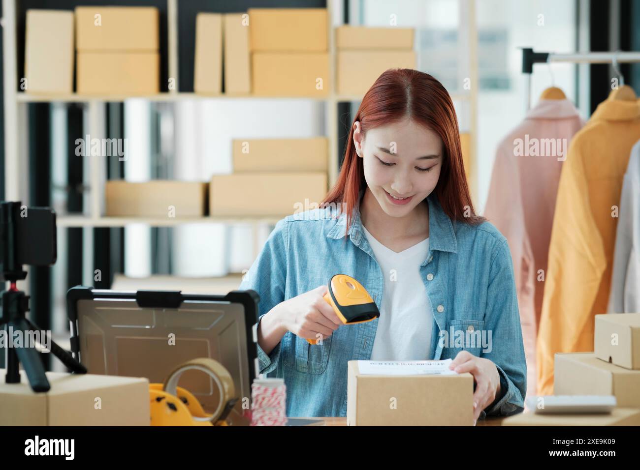 Scannen des Barcodes auf Versandkarton mit Scanner Stockfoto