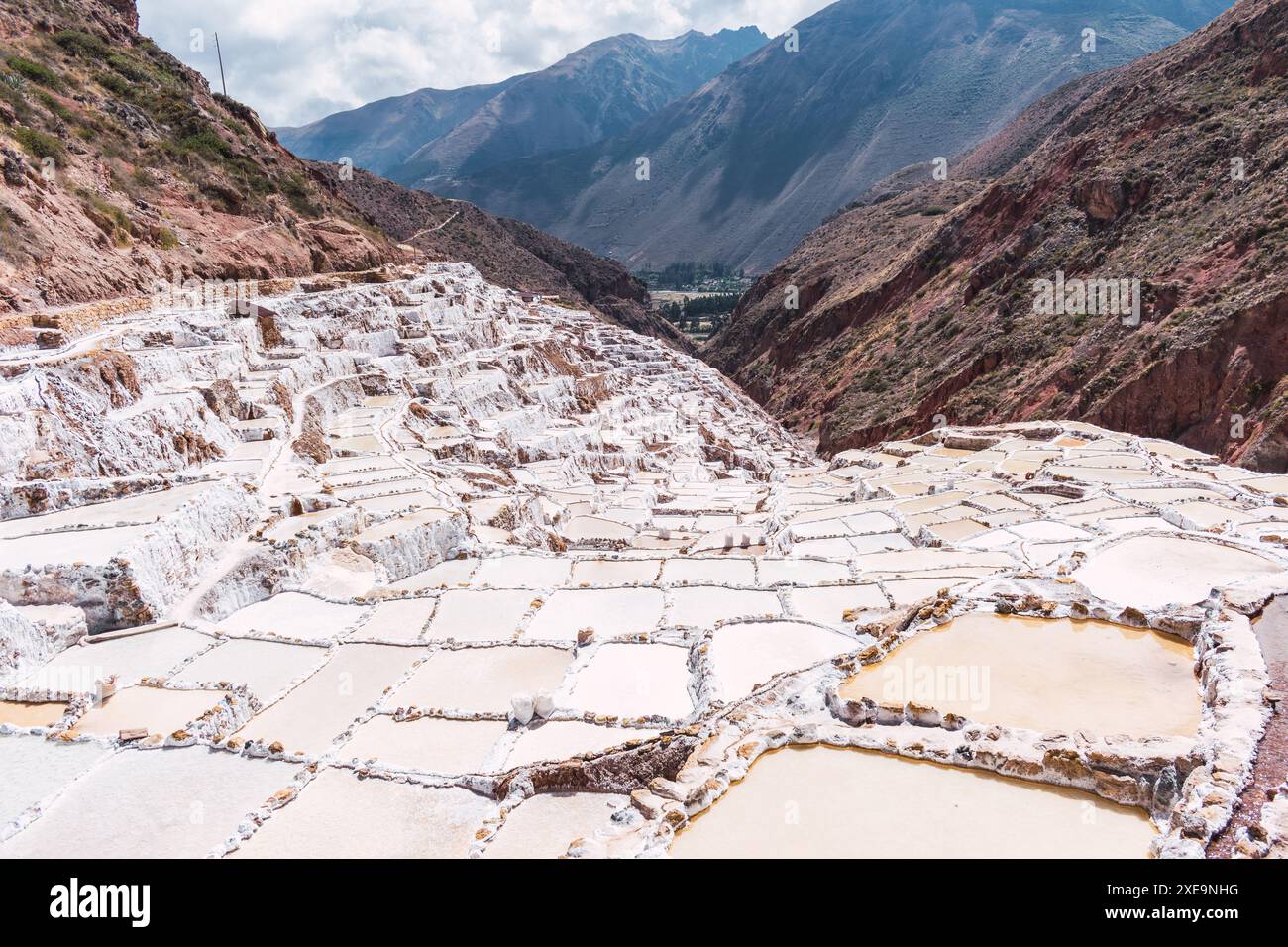 Terrassen von Salineras de Maras im heiligen Tal der inkas, umgeben von Vegetation an einem sonnigen Sommertag in peru Stockfoto