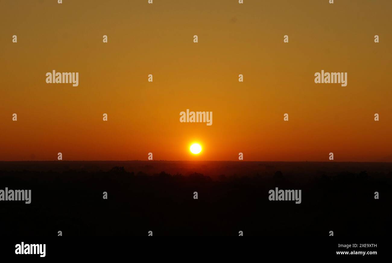 Während eines Sonnenaufgangs in Bagan übergeht die Sonne den Horizont Stockfoto