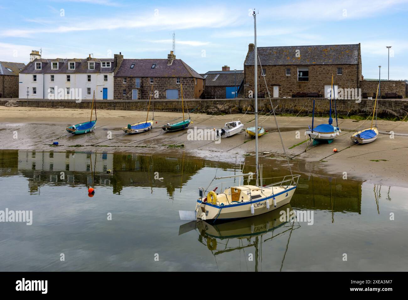 Der Stonehaven Harbour in Aberdeenshire ist eine malerische Szene mit farbenfrohen Booten im Hafen, vor dem Hintergrund historischer Gebäude. Stockfoto