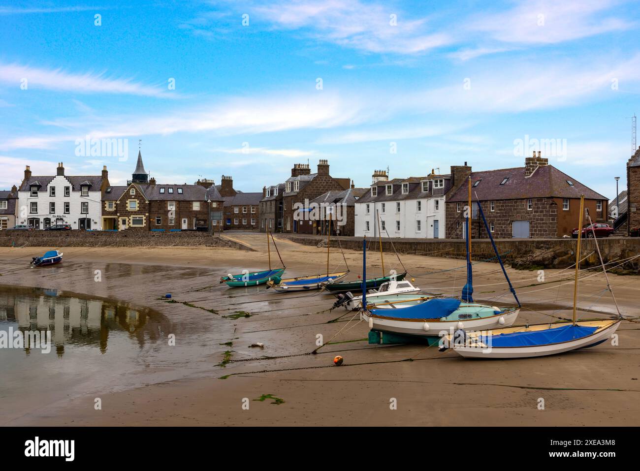 Der Stonehaven Harbour in Aberdeenshire ist eine malerische Szene mit farbenfrohen Booten im Hafen, vor dem Hintergrund historischer Gebäude. Stockfoto
