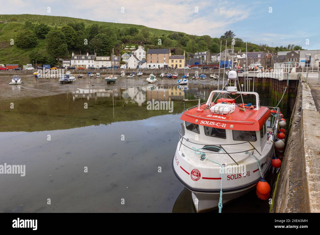 Der Stonehaven Harbour in Aberdeenshire ist eine malerische Szene mit farbenfrohen Booten im Hafen, vor dem Hintergrund historischer Gebäude. Stockfoto