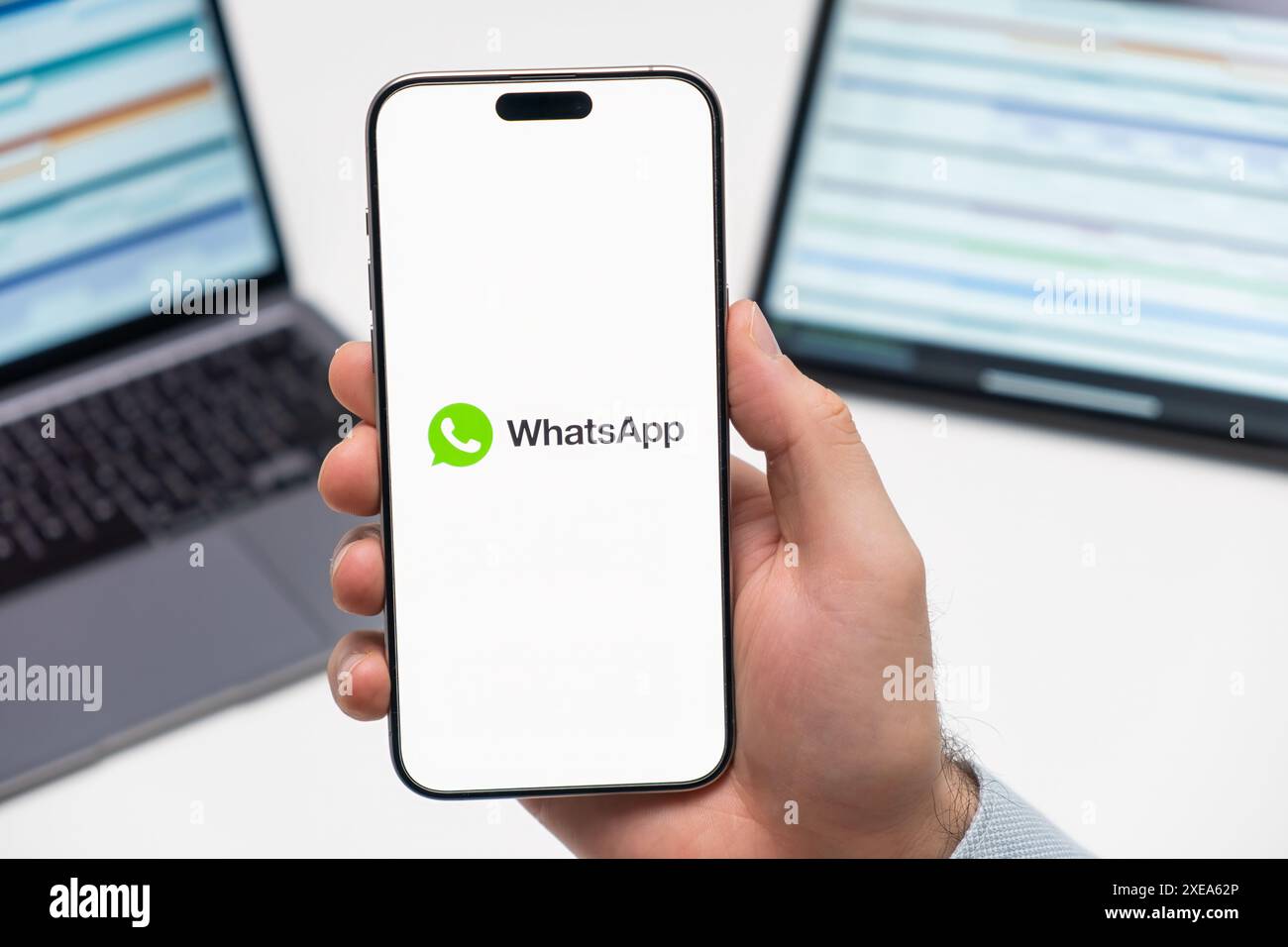 PRAG, TSCHECHISCHE REPUBLIK - 21. JANUAR 2024: WhatsApp-Logo auf dem Bildschirm des Smartphones in der Hand des Mannes auf dem Hintergrund des Arbeitsplatzes. Stockfoto