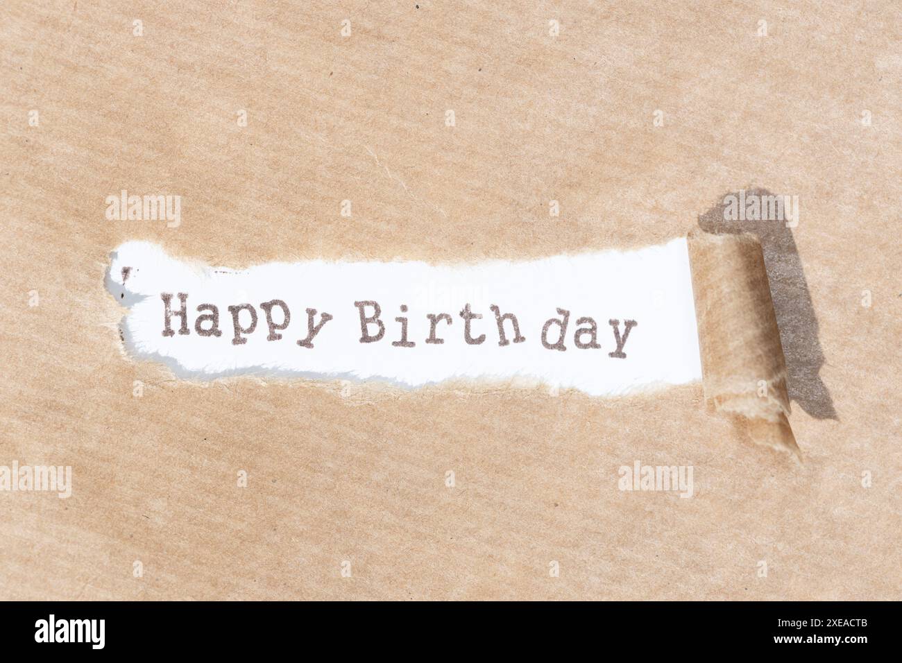 Alles Gute zum Geburtstag. Brauner Papierstreifen mit Text auf weißem Papierhintergrund Stockfoto