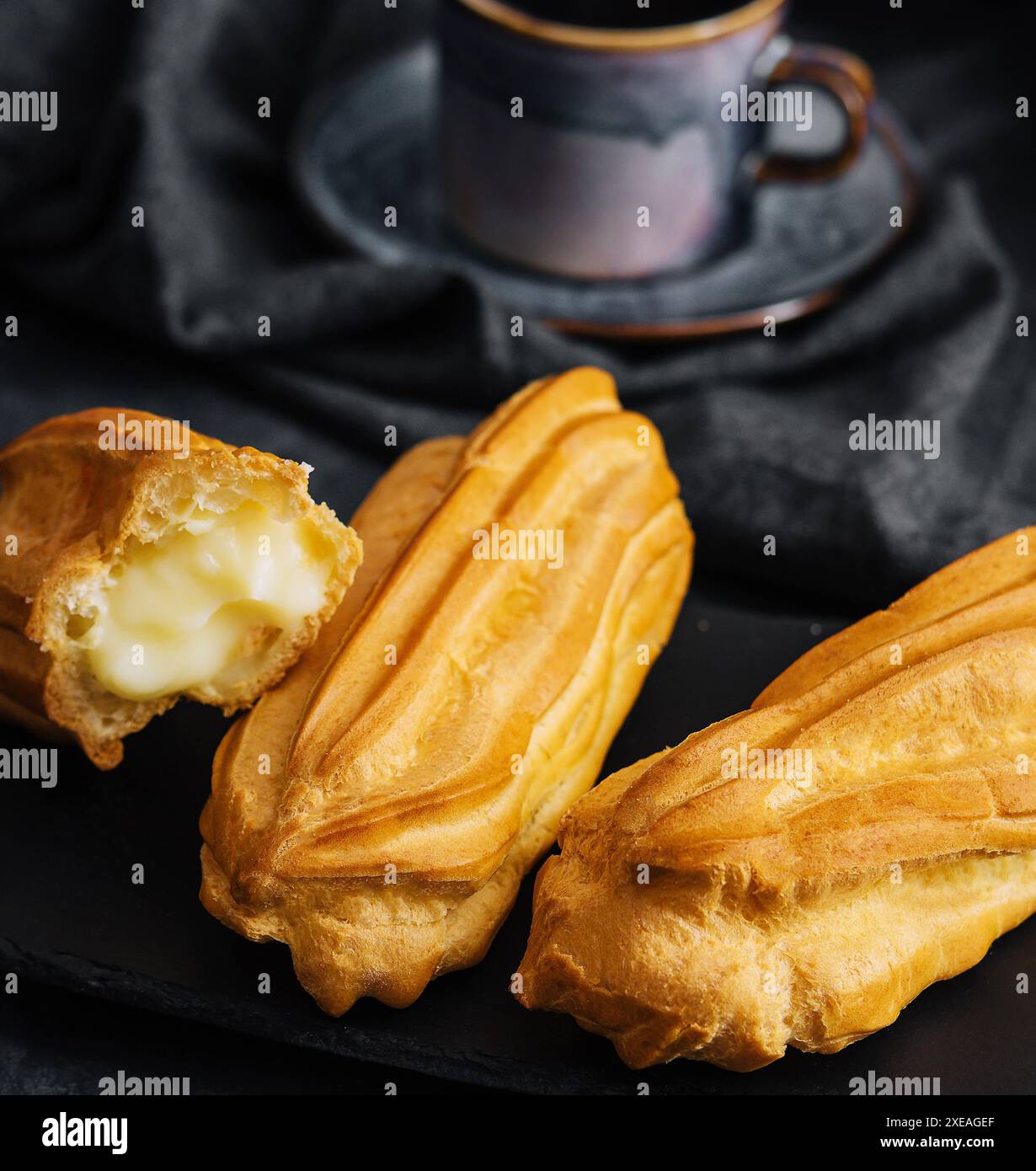 Eclairs mit Creme auf Steinbrett Stockfoto