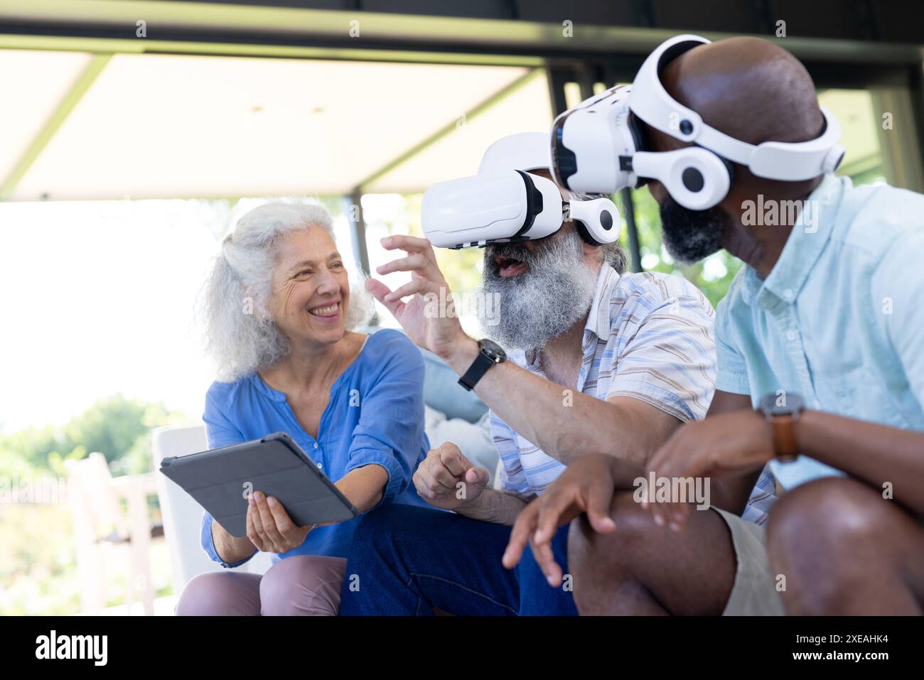 Zu Hause können Seniorenfreunde mit VR-Headsets und -Tablets virtuelle Realität genießen Stockfoto