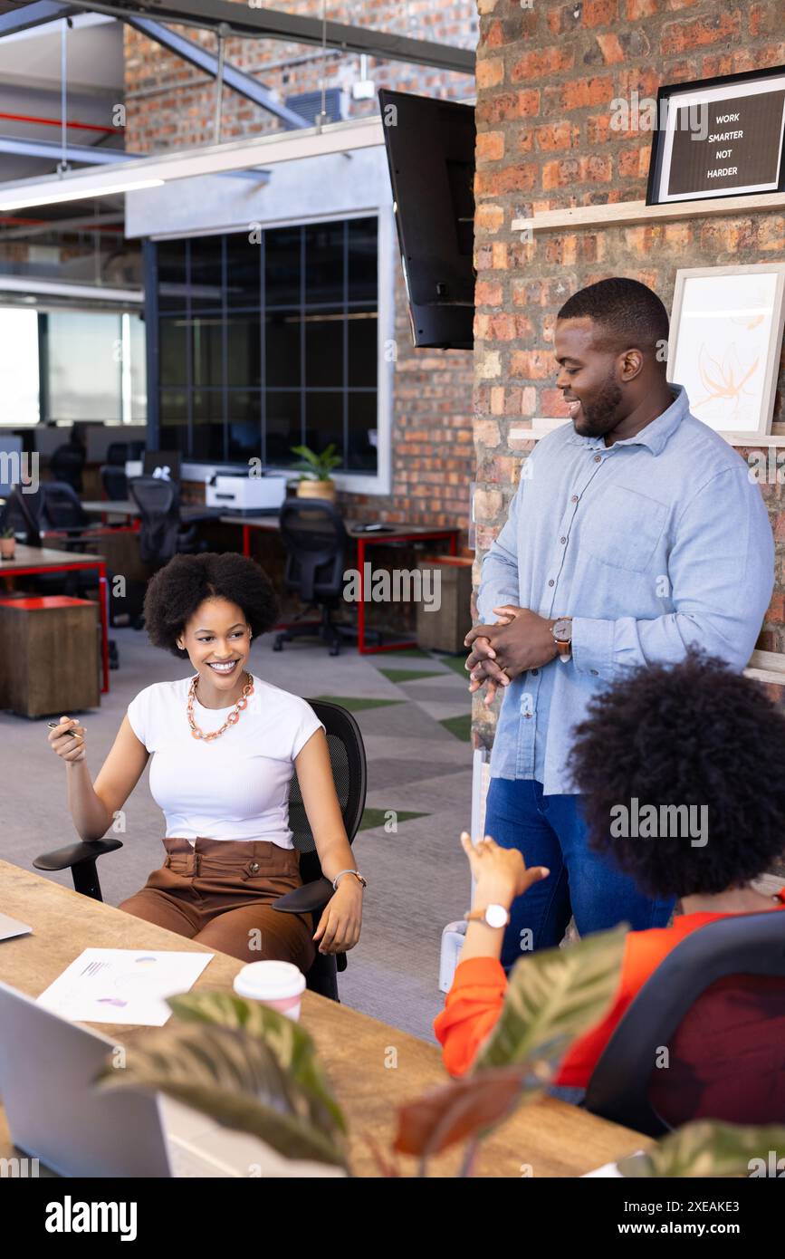 Afroamerikanische Geschäftskollegen diskutieren über Arbeit, lächeln in modernen Büros Stockfoto