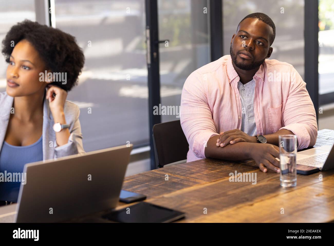 Afroamerikanische Geschäftskollegen bei Gelegenheitsgesprächen mit Laptops im Büro Stockfoto