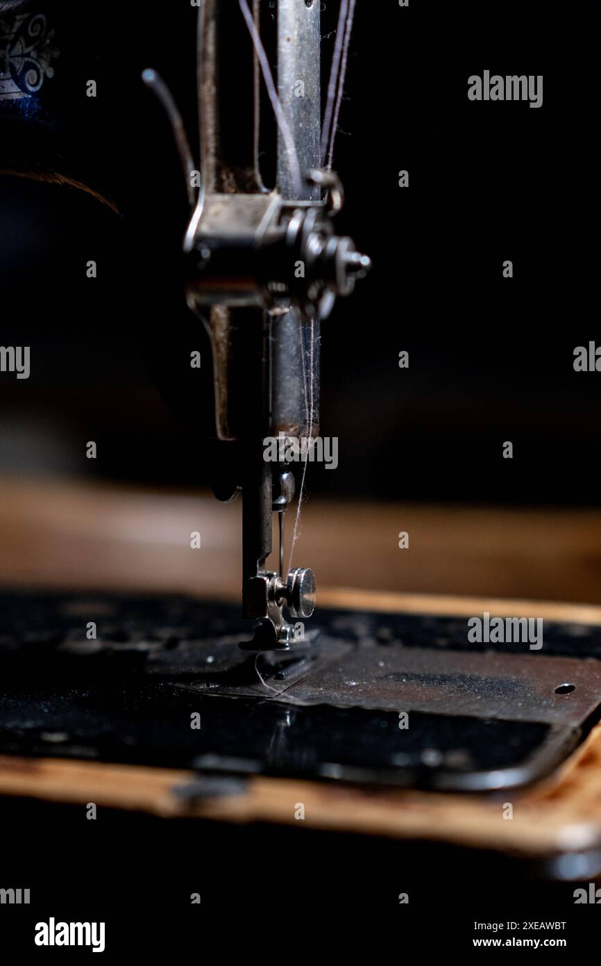 Die alte Nähmaschine steht zu Hause auf dem Tisch und ist einsatzbereit. Stockfoto