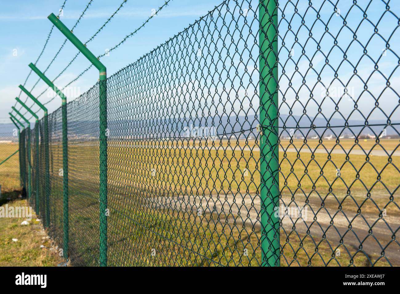 Grüner Gitterzaun aus Stahldraht um den Flughafenbereich. Eingeschränkter Schutz der Bereiche. Stockfoto