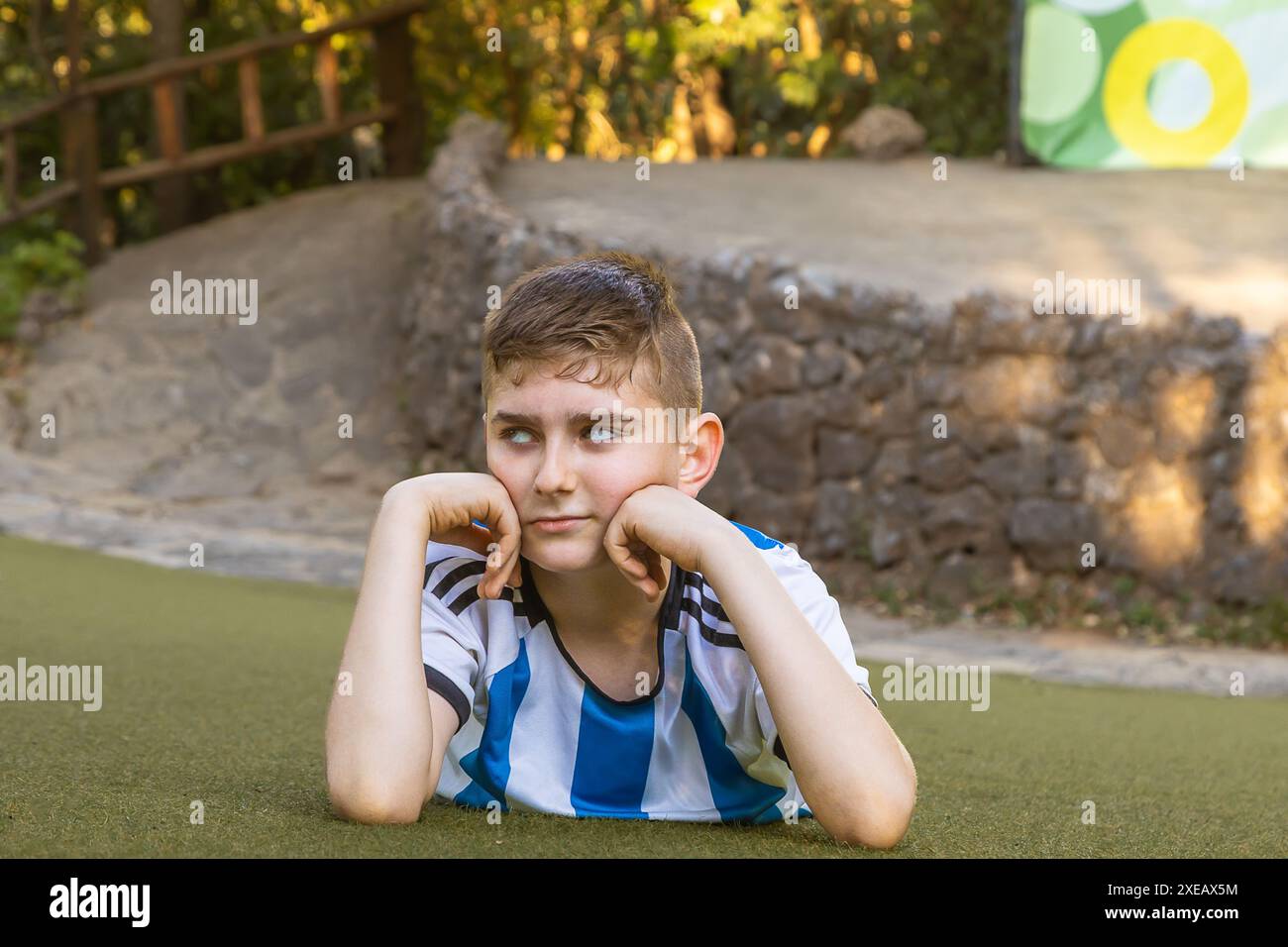 Junge, gekleidet als Sportler, der auf dem Gras posiert Stockfoto