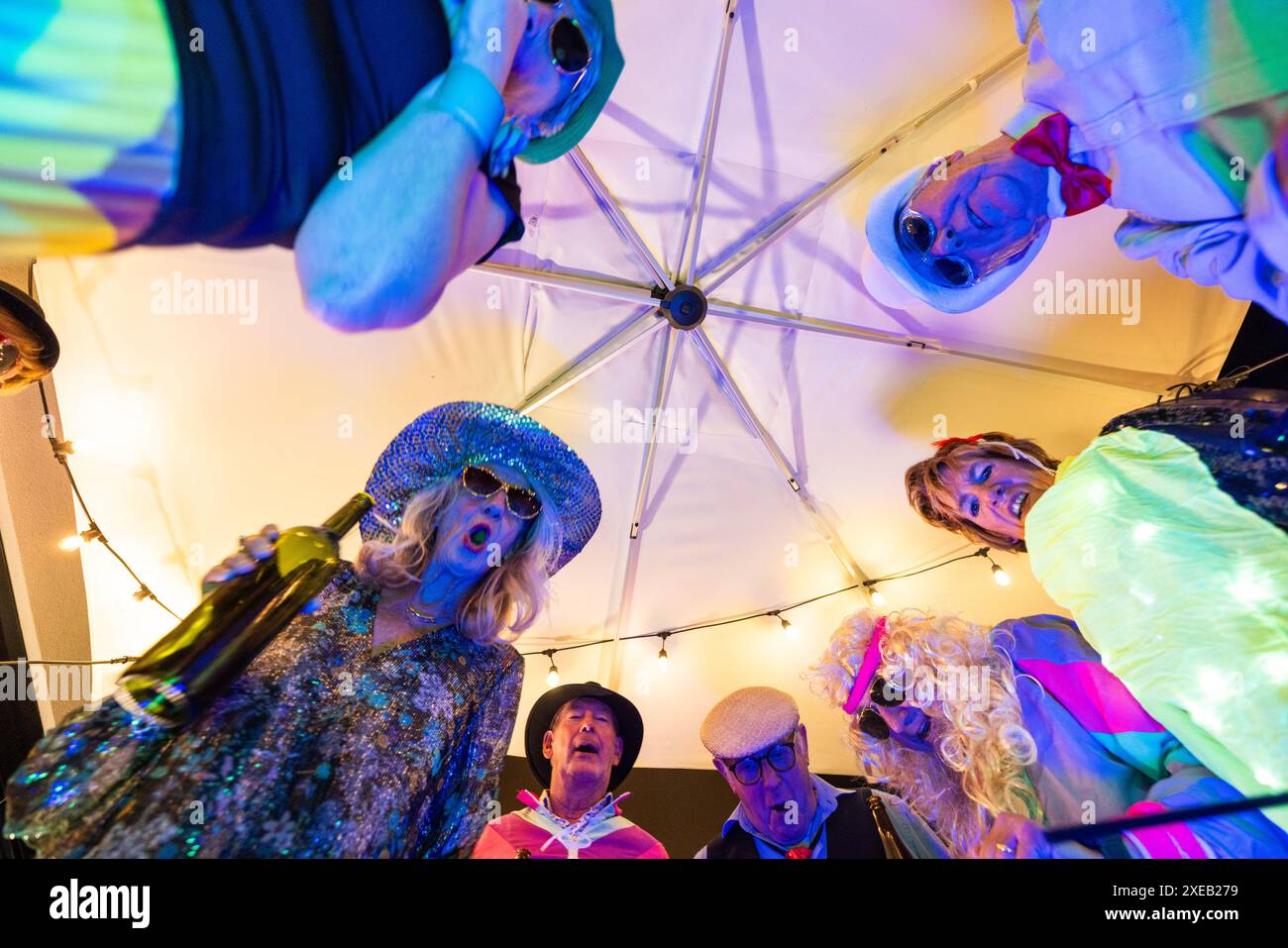 Dynamischer Blick auf eine Seniorenkostümparty unter dem Sonnenschirm Stockfoto