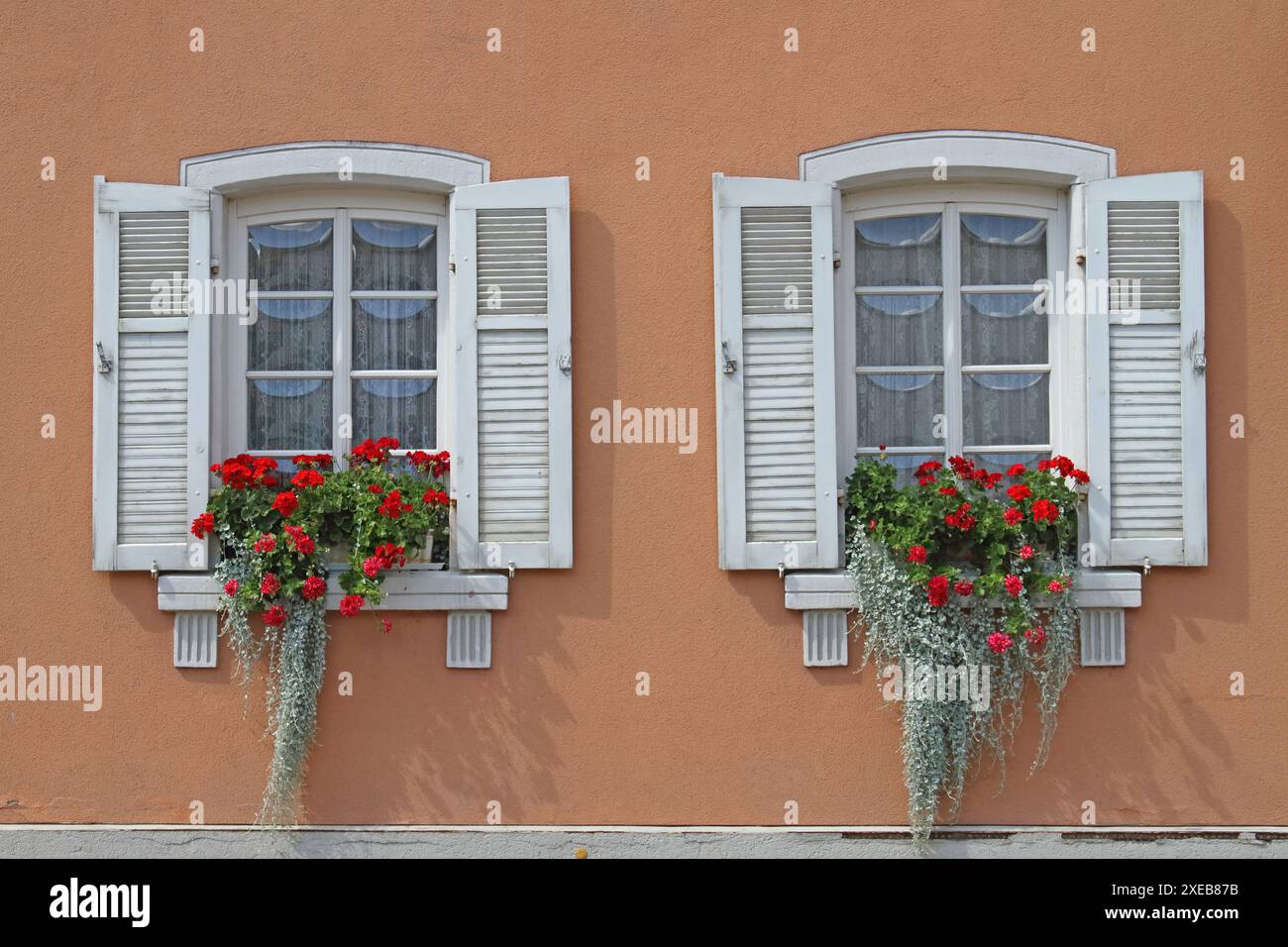 Fenster in historischem Gebäude mit Bogenverglasung und Blumendekoration Stockfoto