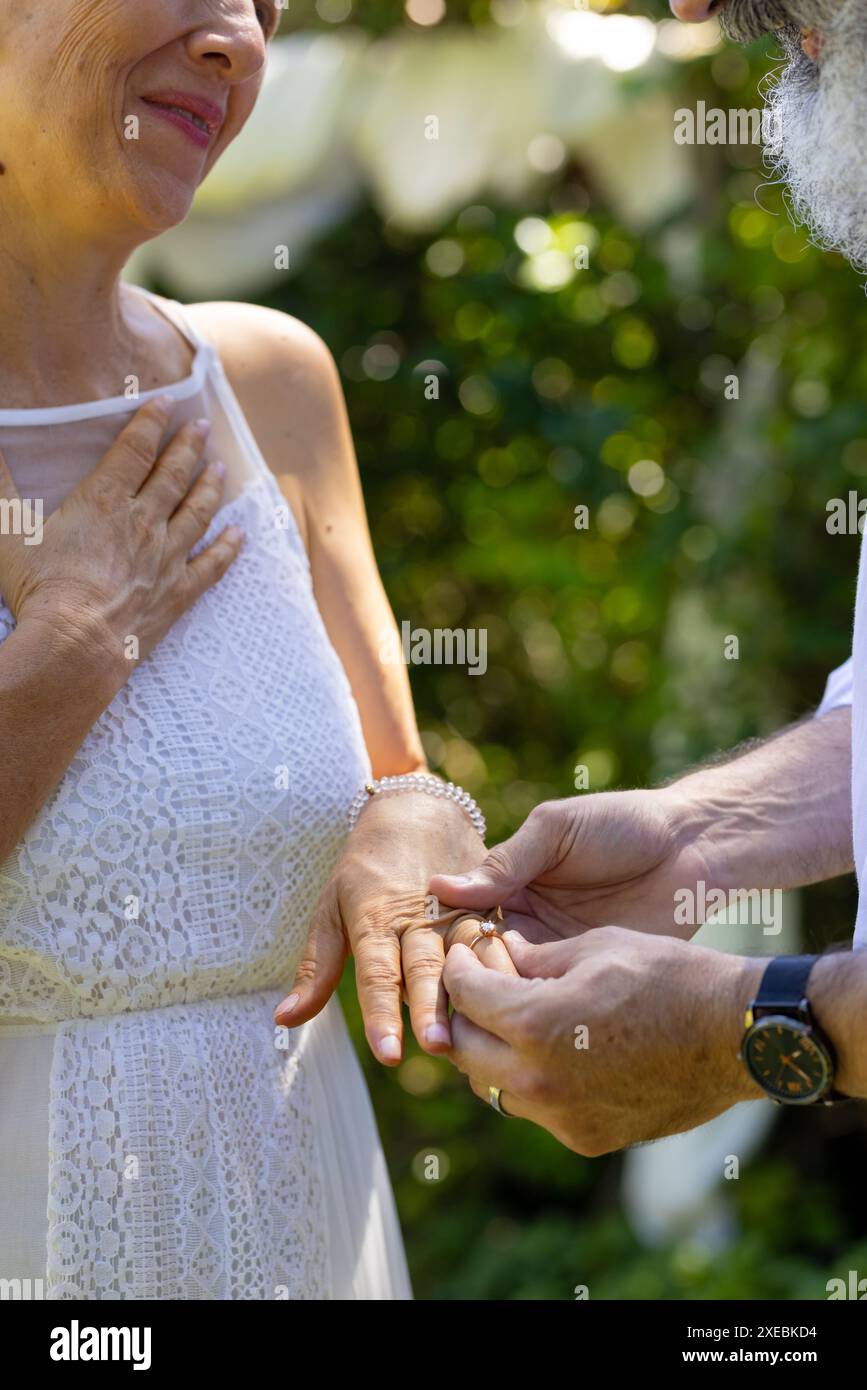 Seniorenpaar tauscht bei einer Zeremonie im Freien Ringe aus, um Liebe und Engagement zu feiern Stockfoto