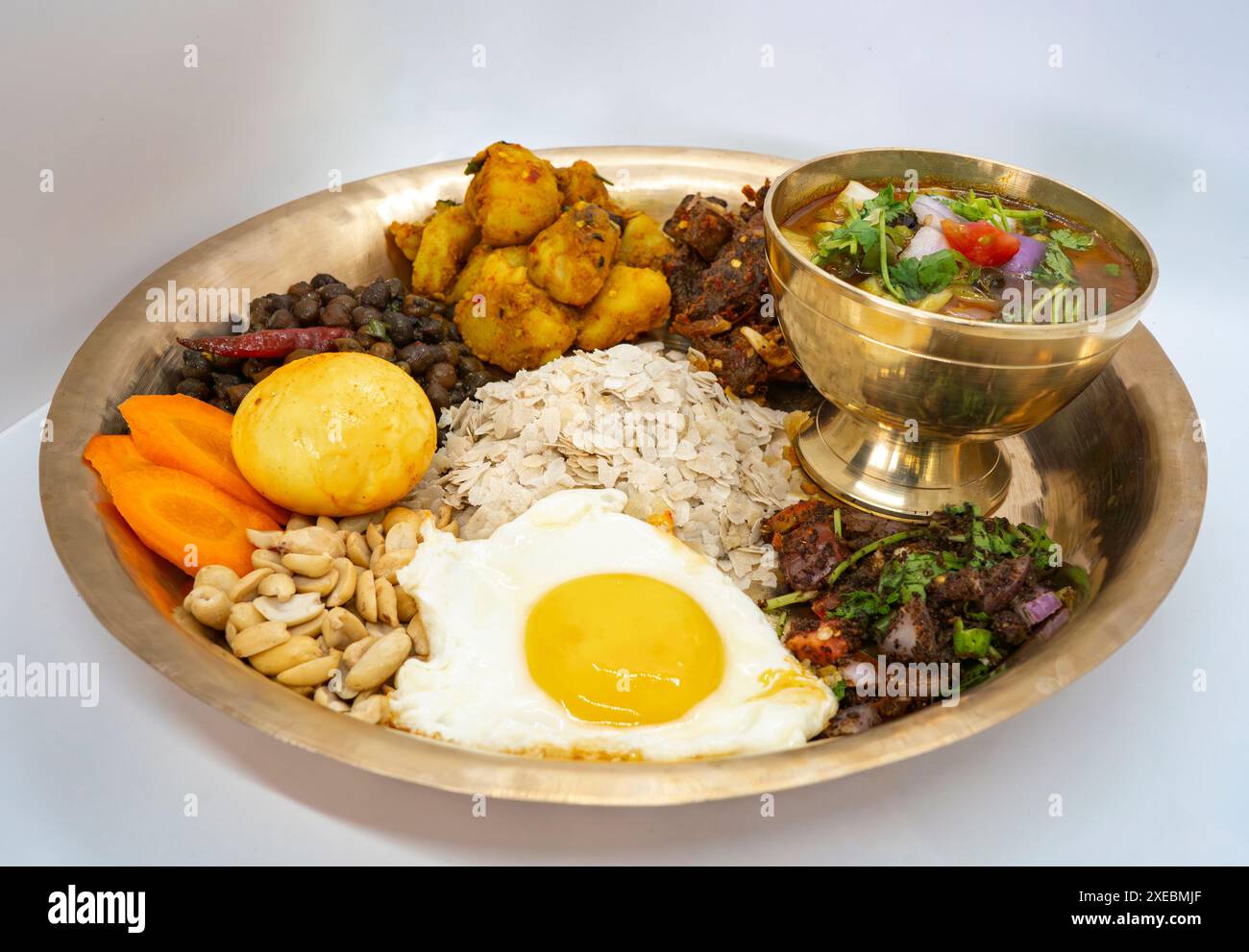 Newari Khaja Set typisch nepalesischer Thali mit Reisflocken, Choyila, Eiern, Kichererbsen, Tama, Bambussuppe, Mittagessen Aalu Sadheko Stockfoto