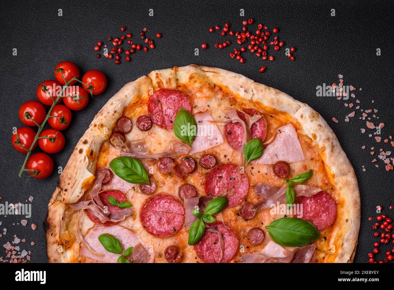 Köstliche frisch gebackene Pizza mit Salami, Fleisch, Käse, Tomaten Stockfoto