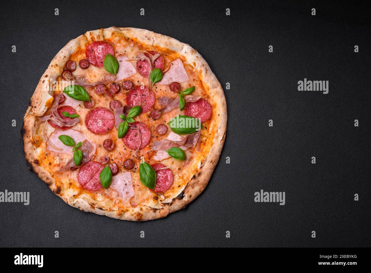 Köstliche frisch gebackene Pizza mit Salami, Fleisch, Käse, Tomaten Stockfoto