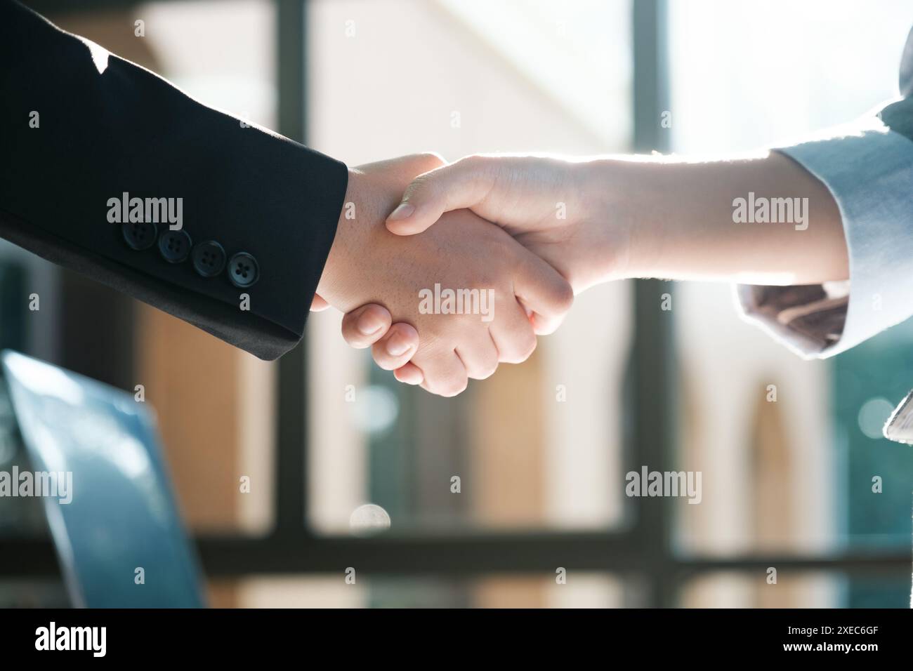 Zwei Leute schütteln sich die Hände in einem Geschäftsumfeld Stockfoto