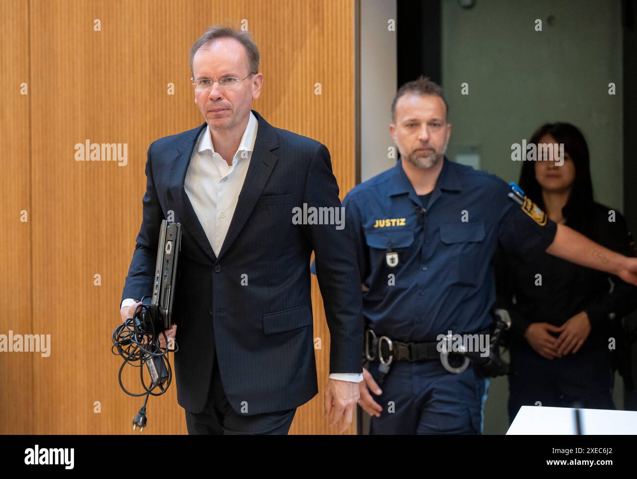 München, Deutschland. Juni 2024. Der ehemalige Wirecard-Chef Markus Braun wird von Gerichtsbeamten in den Gerichtssaal begleitet. Im größten Betrugsfall in der deutschen Nachkriegsgeschichte wurden Braun und zwei weitere ehemalige Wirecard-Manager wegen mutmaßlichen kommerziellen Bandenbetrugs angeklagt. Laut der Anklageerhebung sollen sie seit 2015 die Bilanzen von Wirecard gefälscht und Kreditbanken um 3,1 Milliarden Euro betrogen haben. Quelle: Peter Kneffel/dpa/Alamy Live News Stockfoto