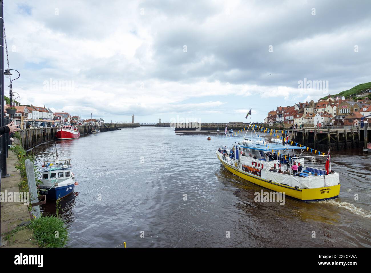 Das Vergnügungs-Kreuzfahrtschiff fährt vom Hafen von Whitby mit zahlreichen Urlaubern in die Nordsee, die ihren Bankurlaub mit einem Aufenthalt in Großbritannien genießen Stockfoto