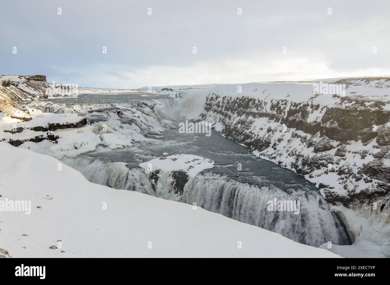 Die majestätischen Gullfoss-Wasserfälle dampfen über isländischen Felsen im Land des Feuers und des Eises an diesem hellen Wintertag auf dem goldenen Kreis. Stockfoto