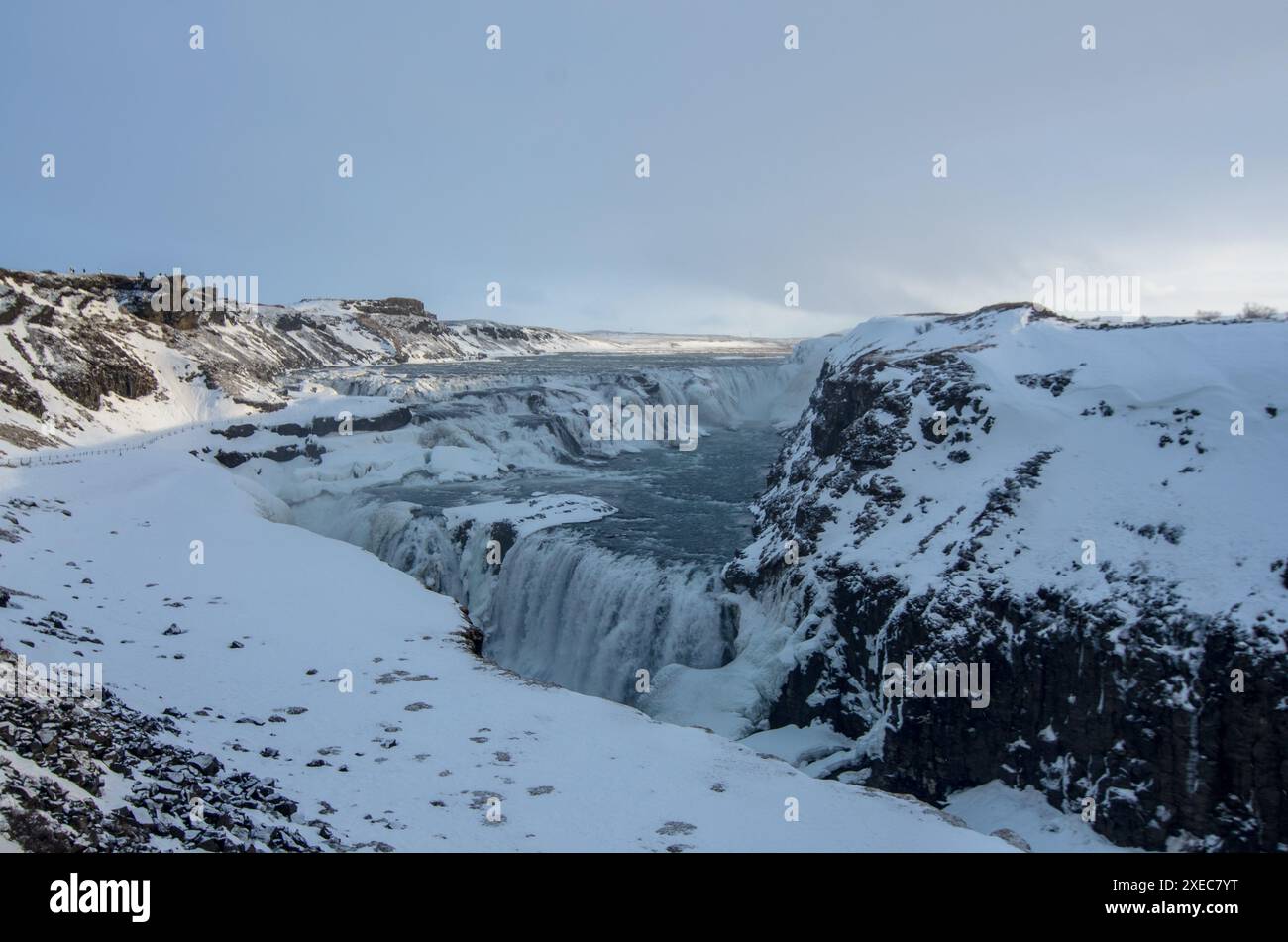 Die majestätischen Gullfoss-Wasserfälle dampfen über isländischen Felsen im Land des Feuers und des Eises an diesem hellen Wintertag auf dem goldenen Kreis. Stockfoto