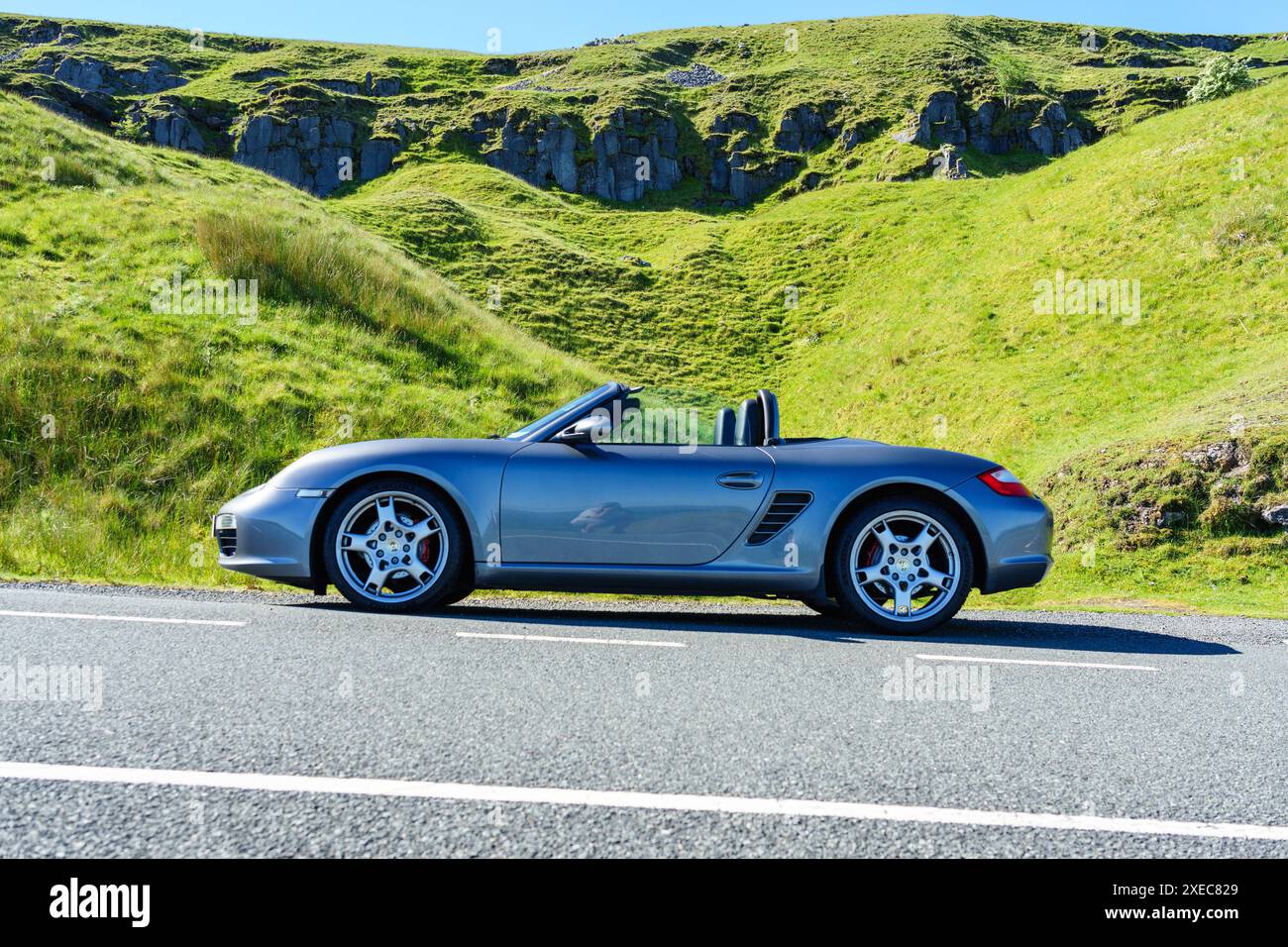 Ein Porsche 987 Boxster Cabriolet steht auf einer walisischen Straße, um das grüne und angenehme Land zu erkunden Stockfoto