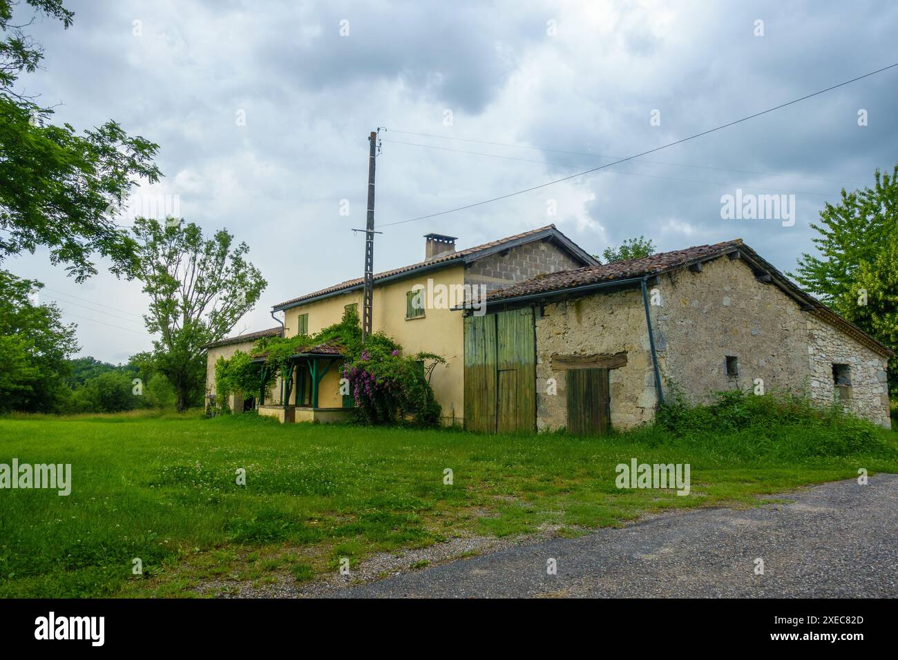 Französisches Bauernhaus im Herzen von Nouvelle Aquitaine liegt an einer ruhigen Landstraße und wartet auf die Rückkehr seiner Besitzer. Schönes Beispiel französischer Architektur Stockfoto