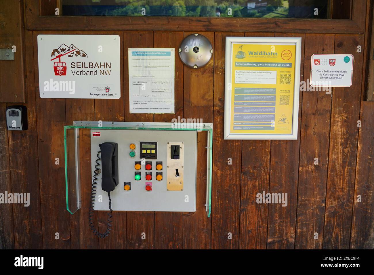 Anton Geisser 27.06.2024 Emmetten NW Schweiz.Kleinstseilbahn. Bild : die Nidwaldner Waldibahn laesst sich neu mit dem handlichen Steuern. Sensoren stoppen die Bahn bei Sturm. Links die alte Bezahlvariante mit Jeton,rechts die neue via QR-Code. *** Anton Geisser 27 06 2024 Emmetten NW Schweiz kleine Seilbahn Bild die Nidwaldner Waldibahn kann nun mit einem Handy gesteuert werden Sensoren stoppen die Seilbahn bei Stürmen Stockfoto