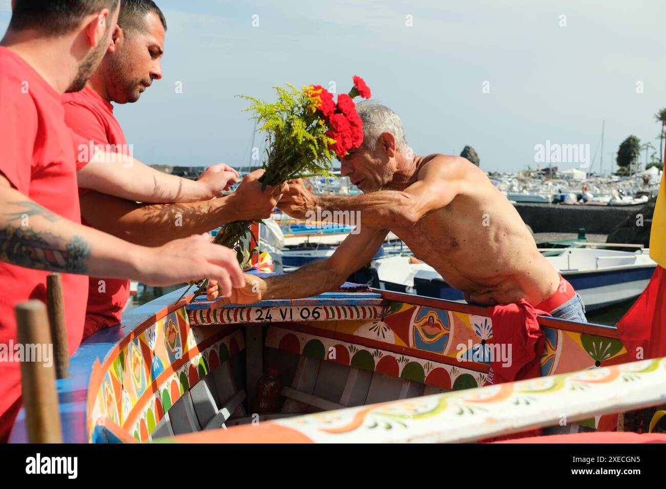 ACI TREZZA, ITALIEN - 24. JUNI 2024 - San Giovanni traditionelle Parade. San Giovanni traditionelle Parade mit Pisci a mari Show, wo sie die Thunfischjagd reproduzieren. Der Thunfisch wird von einem jungen Mann gerührt, der endlich vor den Fischern entkommt Stockfoto