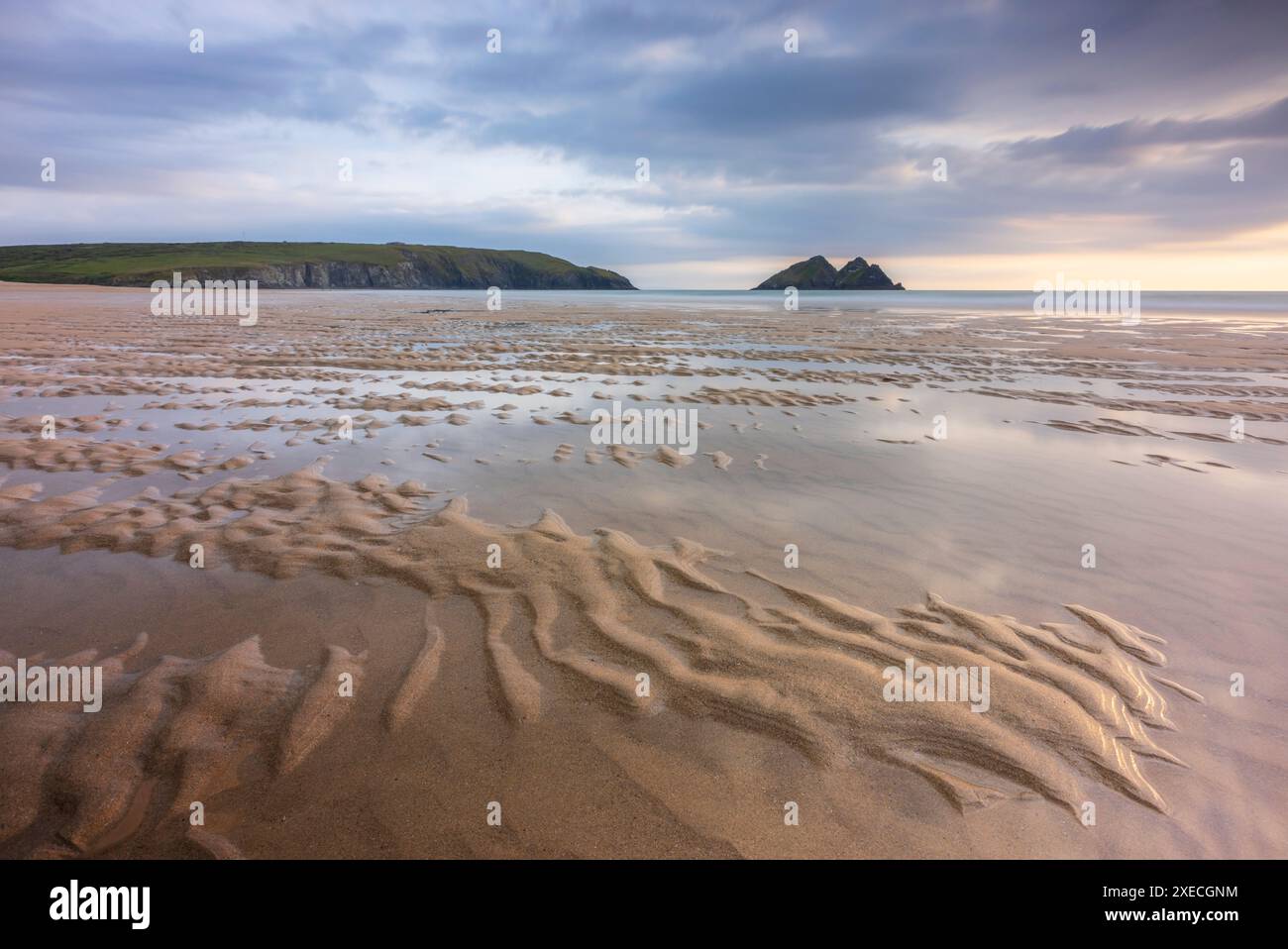 Sommersonnenuntergang über Holywell Bay Beach in der Nähe von Newquay, Cornwall, England. Sommer (Juni) 2024. Stockfoto