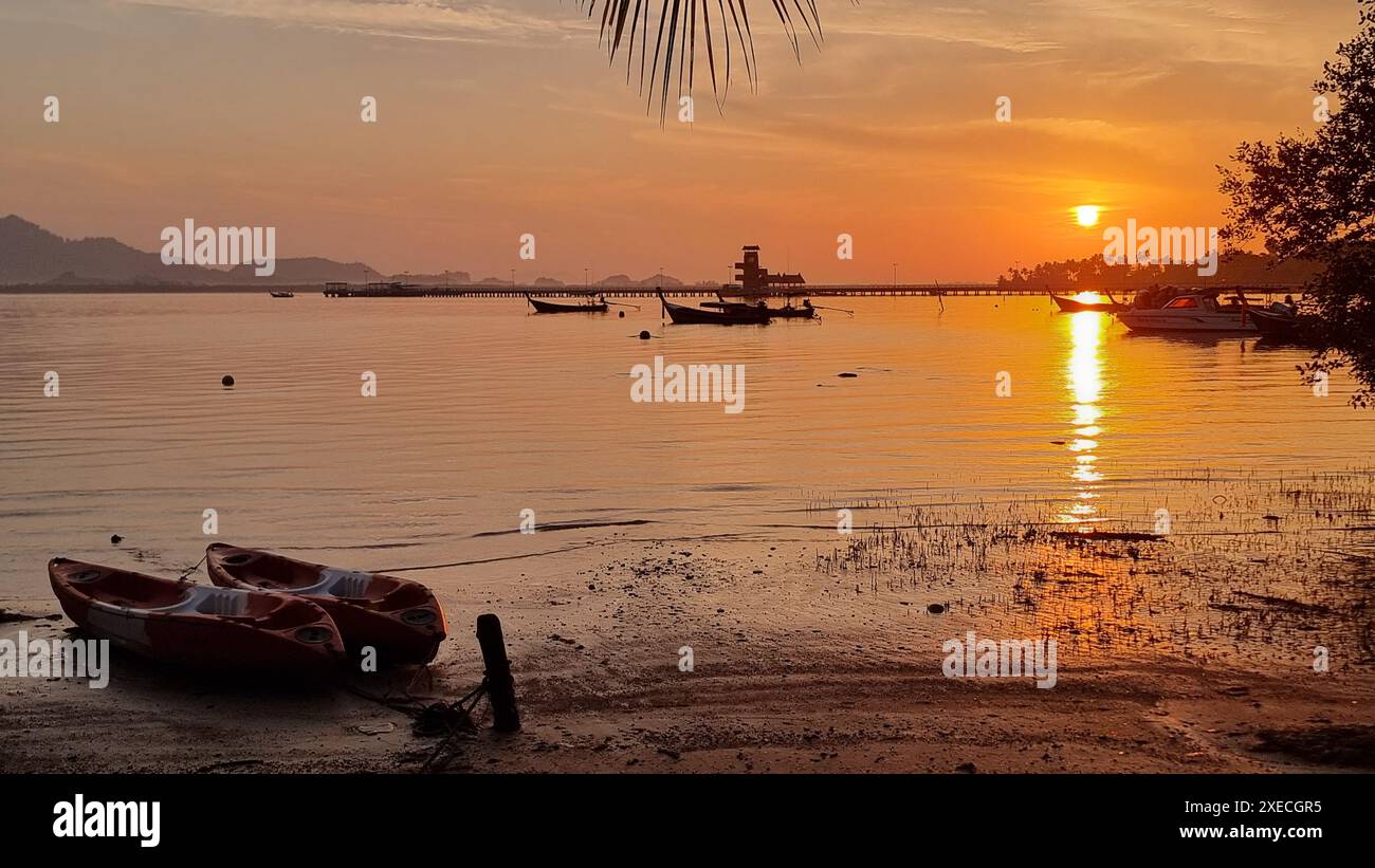 Ein farbenprächtiges Boot ruht friedlich am Sandstrand mit Blick auf das weite Meer Stockfoto