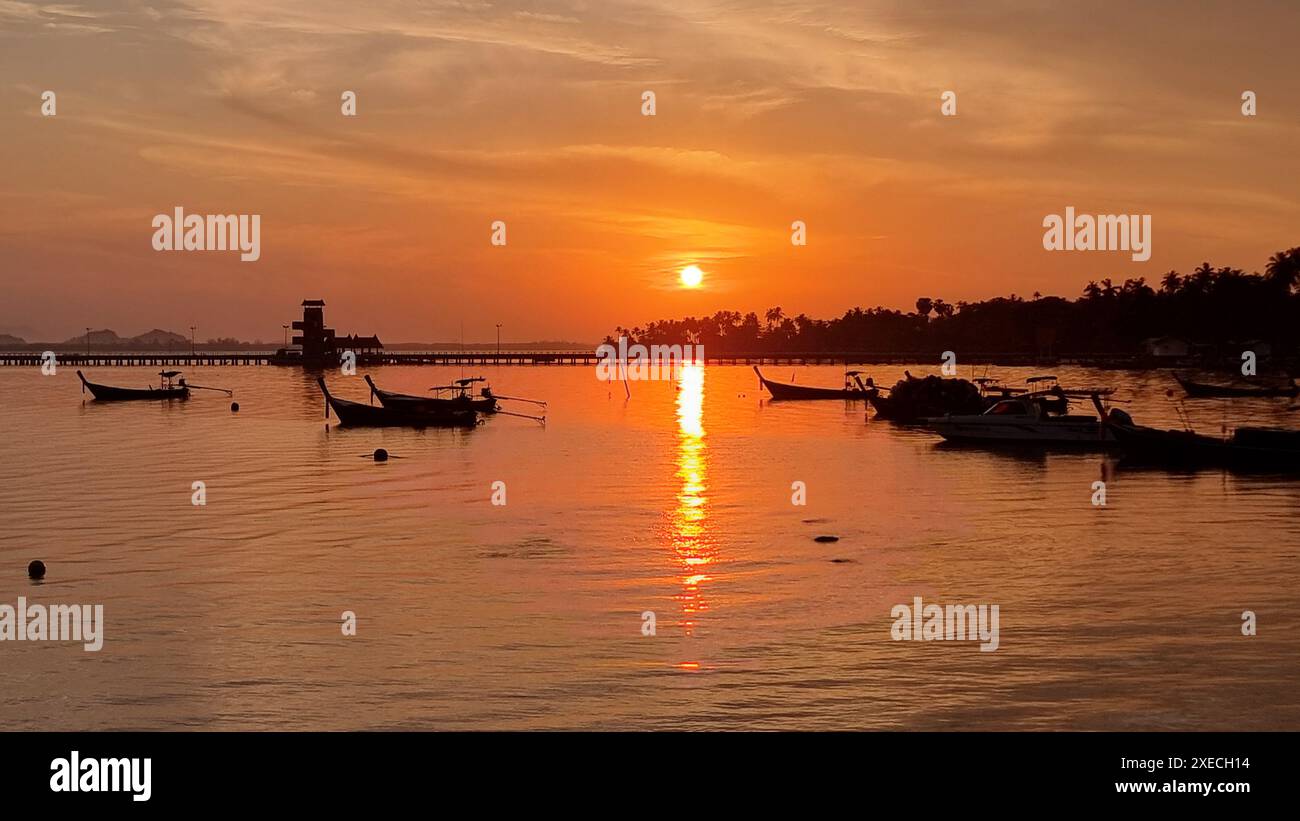 Eine malerische Szene einer Gruppe von Segelbooten, die friedlich unter einem klaren blauen Himmel auf dem Wasser schweben Stockfoto