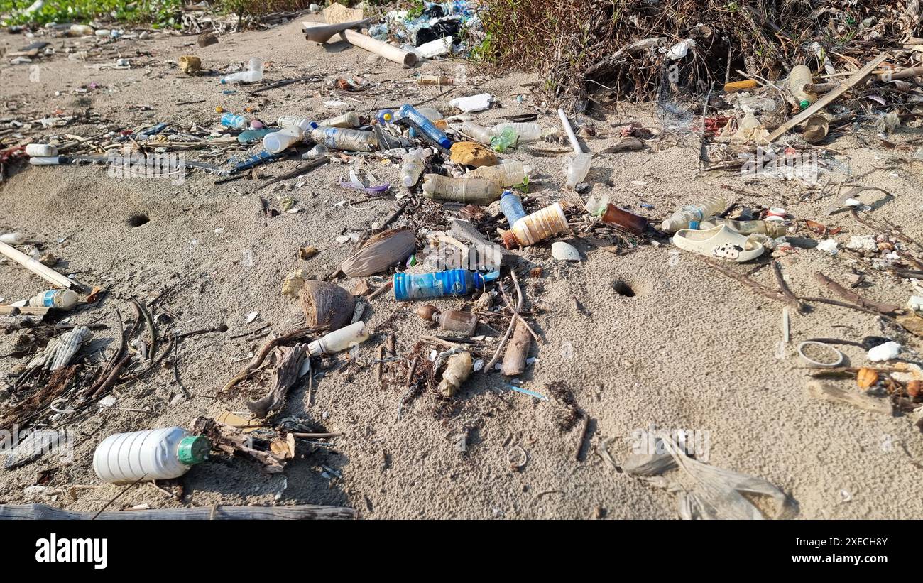 Ein Müllhaufen, der die Ruhe eines Sandstrandes stört und die natürliche Schönheit mit der von Menschen verursachten Verschmutzung kontrastiert Stockfoto