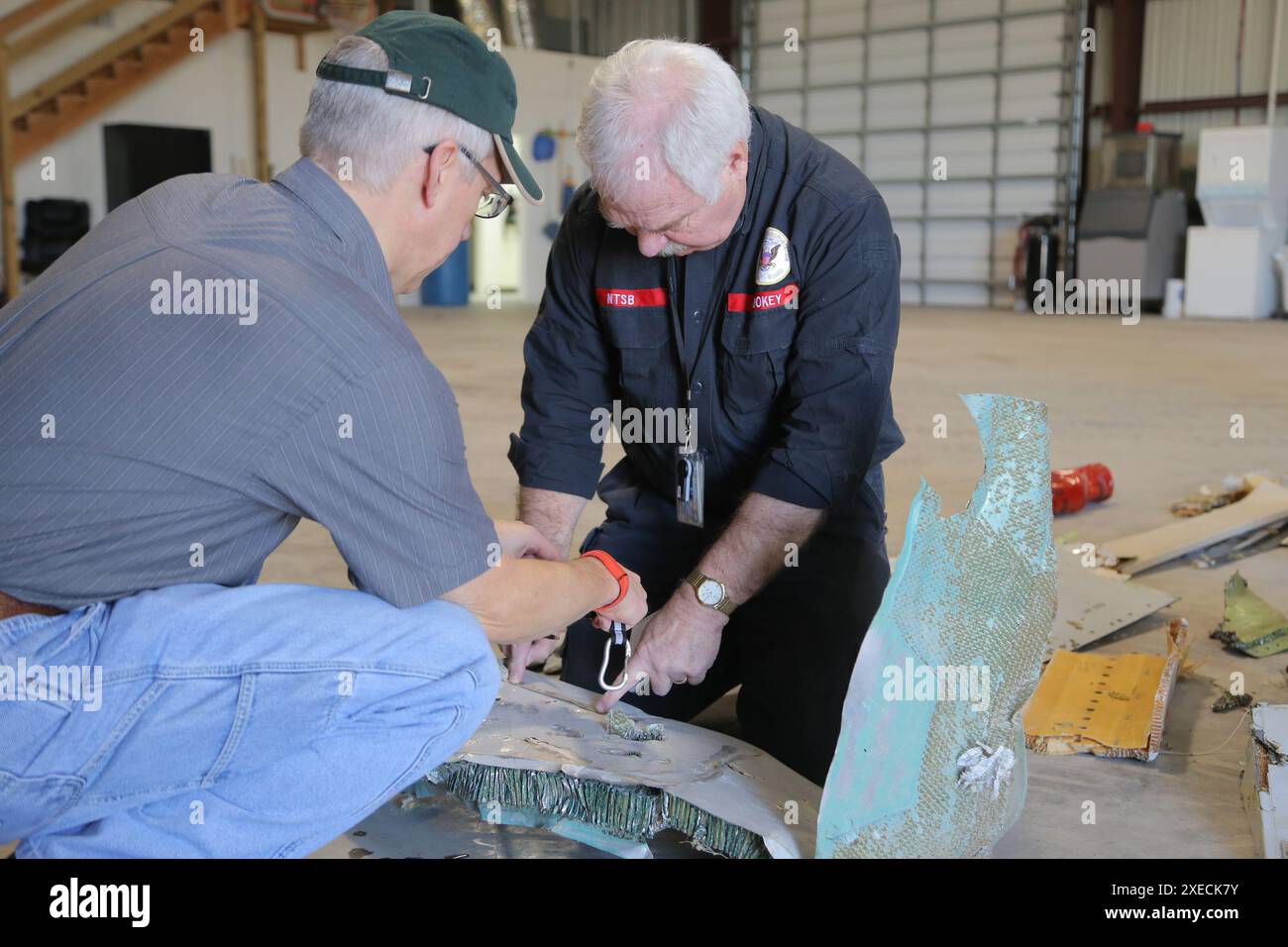 Auf diesem Foto, das am 24. Februar 2019 aufgenommen wurde, untersucht der leitende NTSB-Ermittler Jim Hookey (rechts) mit Dan Kemme von GE Aviation die Wrackteile, die am Tatort des Absturzes des Frachtflugzeuges am 23. Februar 2019 in Texas gefunden wurden. ANAHUAC, Texas - Absturz eines Frachtflugzeugs 23. Februar 2019 auf diesem Foto, das am 24. Februar 2019 aufgenommen wurde, untersucht der leitende NTSB-Ermittler Jim Hookey (rechts) zusammen mit Dan Kemme von GE Aviation die Wrackteile, die am Tatort des Absturzes des Frachtflugzeugs am 23. Februar 2019 in Texas gefunden wurden. Stockfoto