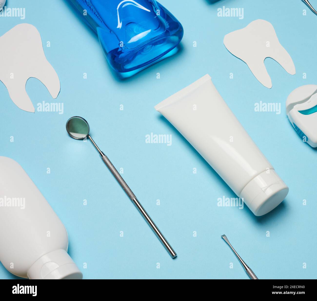 Mundspülung, Zahnpasta, Zahnseide und medizinischer Spiegel auf blauem Hintergrund, Mundhygiene. Draufsicht Stockfoto