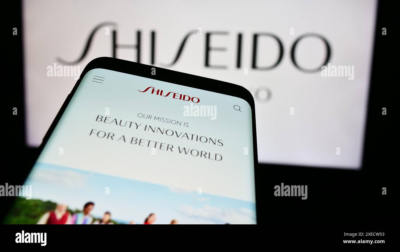 Mobiltelefon mit Webseite des japanischen Kosmetikunternehmens Shiseido Co. Ltd. Vor dem Firmenlogo. Fokussieren Sie sich oben links auf der Telefonanzeige. Stockfoto