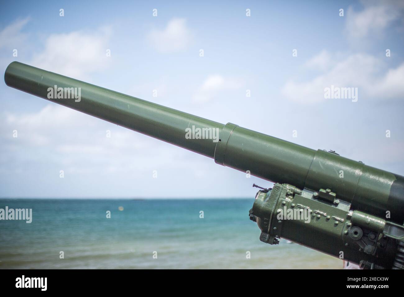 Nahaufnahme einer historischen Militärkanone am Gold Beach, Arromanches, Normandie, Frankreich mit Blick auf die Küste und das Meer. Stockfoto