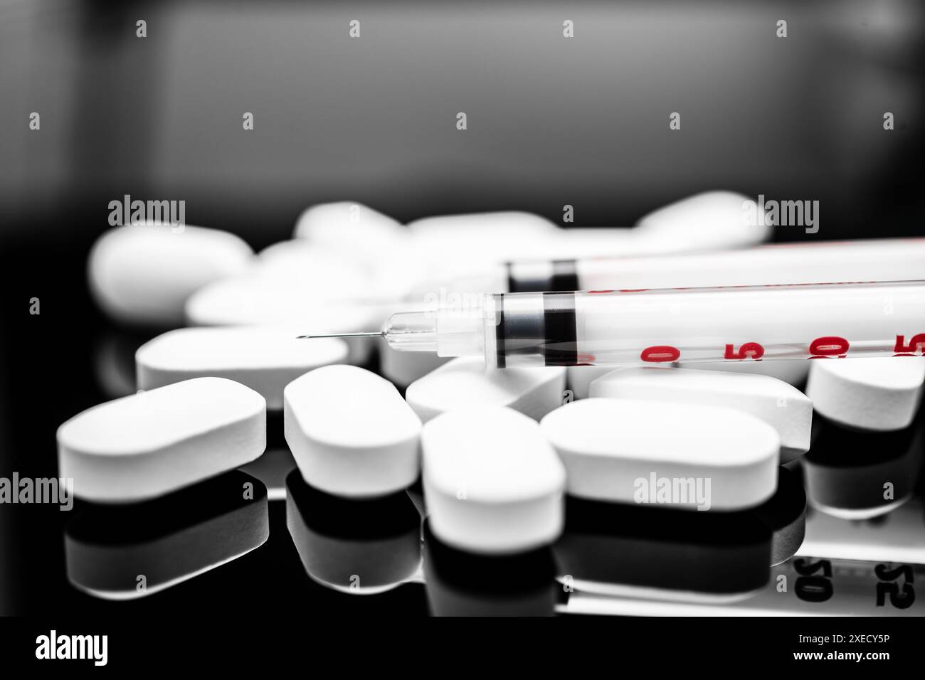 Medizinisches Konzept: Weiße ovale Pillen und Spritze auf einer reflektierenden Oberfläche, Fokus auf Gesundheitswesen und verschreibungspflichtige Praktiken, verschreibungspflichtige Medikamente, Fentanyl Stockfoto