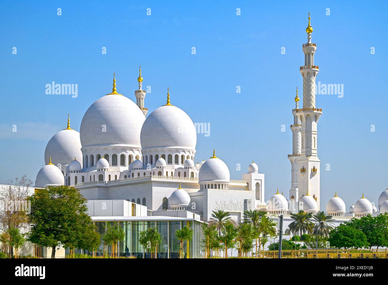 Kuppeln der Scheich-Zayed-Moschee vor blauem Himmel während des sonnigen Tages in Abu Dhabi in den Vereinigten Arabischen Emiraten Stockfoto