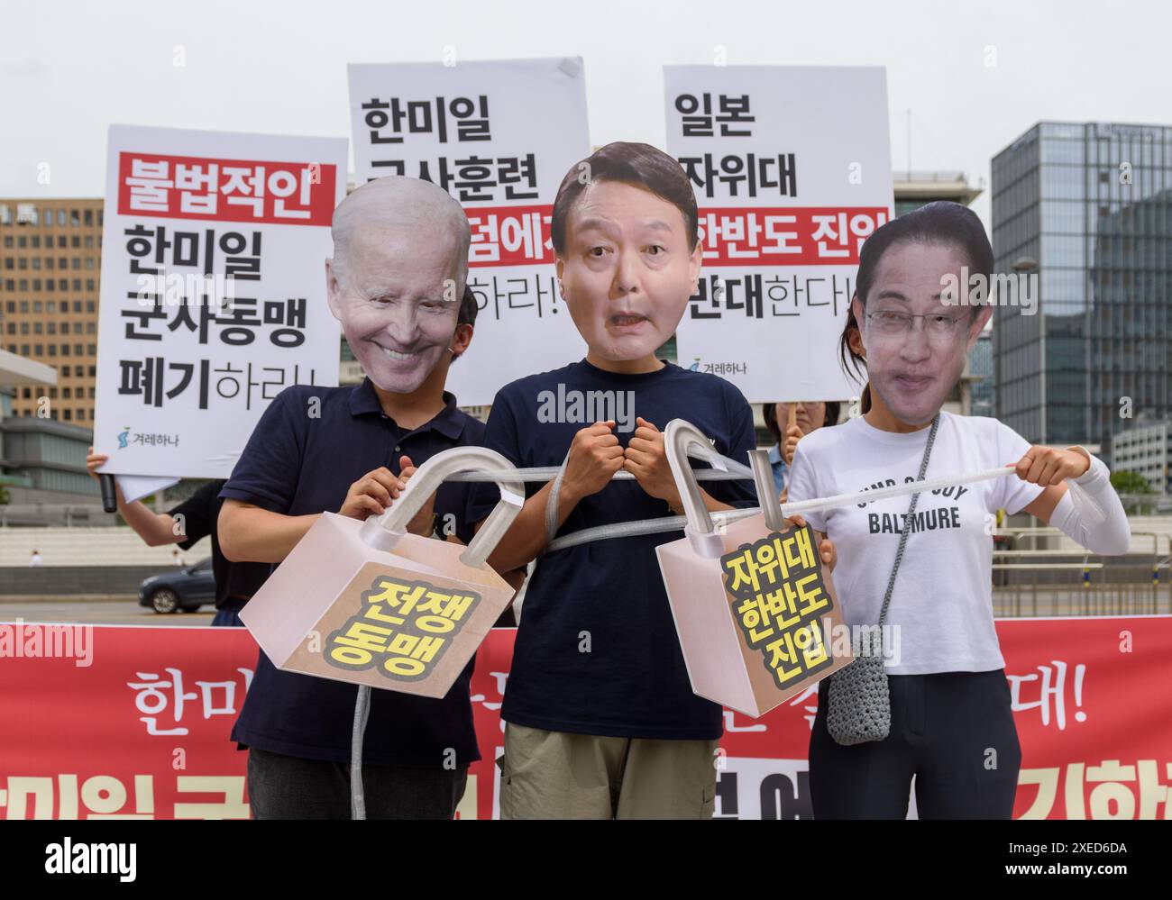 Mitglieder der südkoreanischen Bürgergruppe Gyeorehana (Bewegung für ein Korea), die Masken des südkoreanischen Präsidenten Yoon Suk Yeol (C) tragen, US-Präsident Joe Biden (L) und Japans Premierminister Fumio Kishida (R) treten mit Pappausschnitten auf, die Vorhängeschlösser mit der Aufschrift "war Alliance" zeigen, während eines Protests gegen eine trilaterale militärische Übung namens "Freedom Edge" vor der US-Botschaft in Seoul. Südkorea, die USA und Japan starteten am 27. Juni große neue militärische Übungen, so Südkoreas Joint Chiefs of Staff, als die Verbündeten versuchen, der wachsenden Bedrohung durch Nordkorea entgegenzuwirken. Südkoreanische Bürgergruppe Gyeo Stockfoto