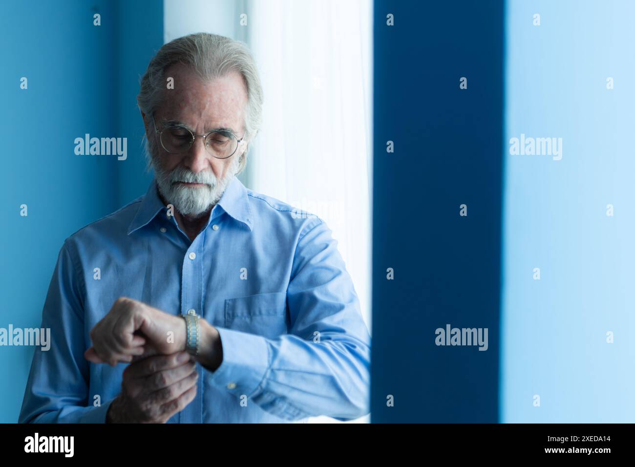 Lächelnder Senior Cowboy mit Uhr und stilvollem Hut Stockfoto