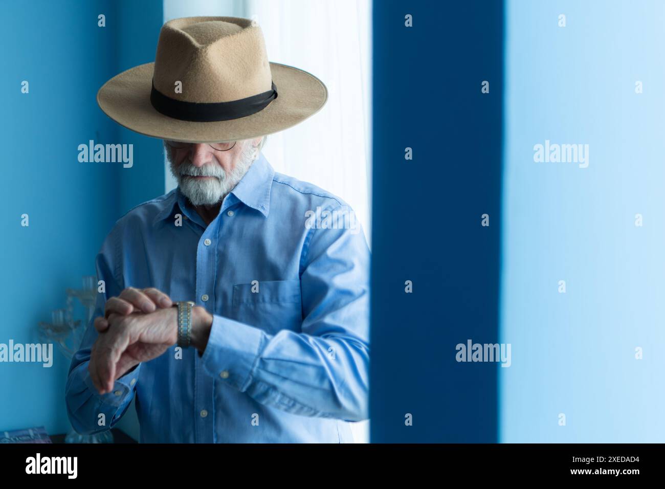 Lächelnder Senior Cowboy mit Uhr und stilvollem Hut Stockfoto