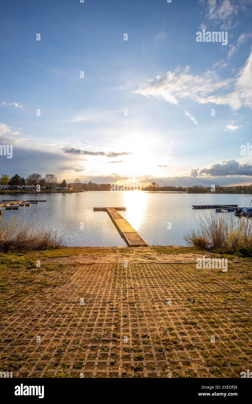 Sonnenuntergang auf einem ruhigen See in einem Tal, umgeben von einem Wald Dutenhofener See Stockfoto