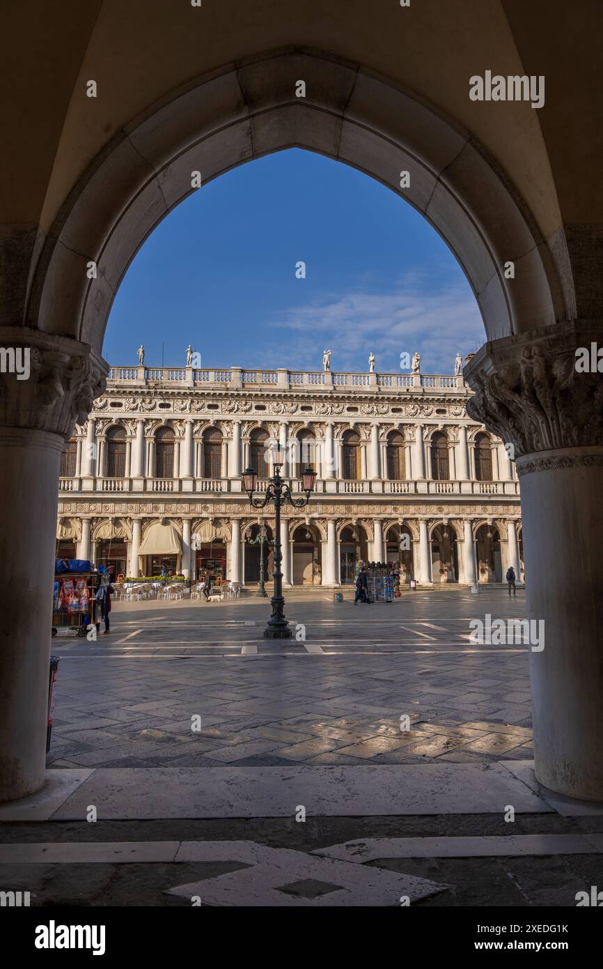 Venedig, Italien, Marciana Bibliothek eingerahmt von einem Bogen des Dogenpalastkolonnade am Markusplatz (Piazza San Marco). Wahrzeichen von 1537 und 1588 von Jacopo Stockfoto