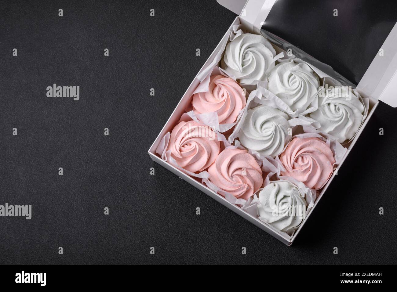 Köstliches süßes mehrfarbiges Marshmallow auf dunklem Betonhintergrund Stockfoto