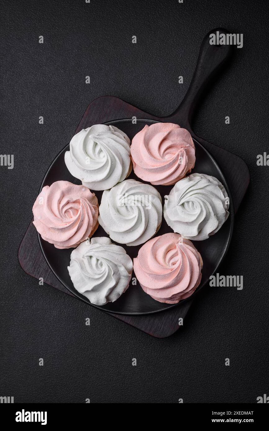 Köstliches süßes mehrfarbiges Marshmallow auf dunklem Betonhintergrund Stockfoto