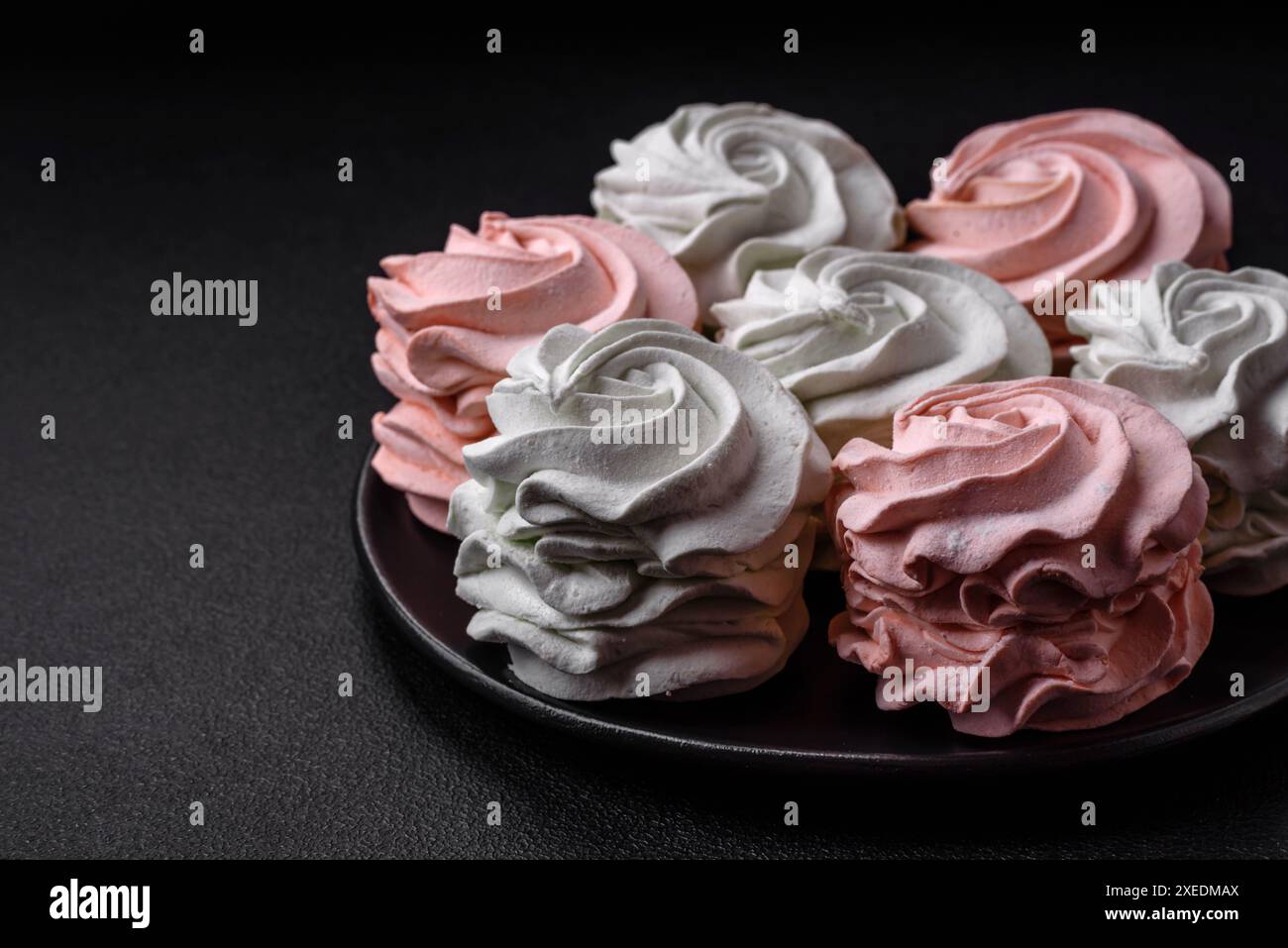 Köstliches süßes mehrfarbiges Marshmallow auf dunklem Betonhintergrund Stockfoto